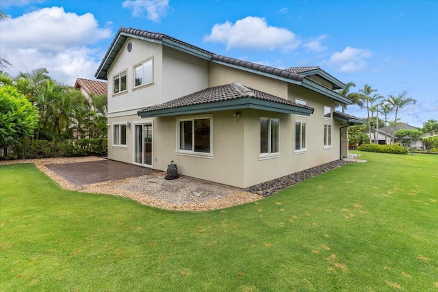 rear view of house featuring a yard and a patio