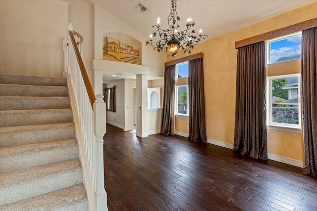 foyer featuring an inviting chandelier, dark hardwood / wood-style floors, and high vaulted ceiling