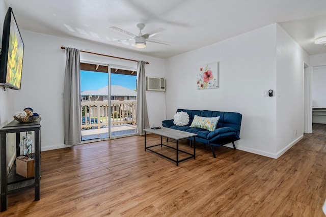 sitting room with wood-type flooring, a wall mounted air conditioner, and ceiling fan