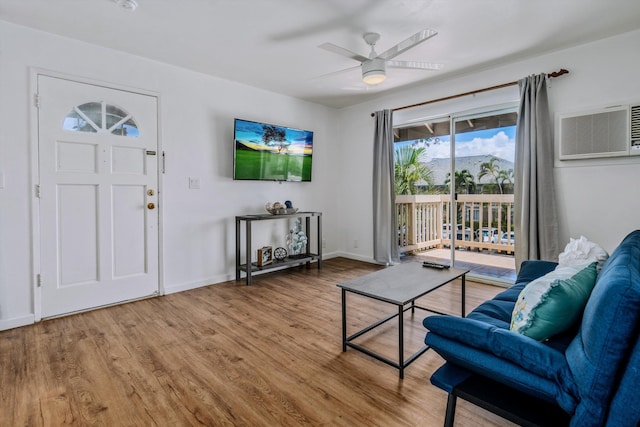 living room with ceiling fan, hardwood / wood-style flooring, and a wall mounted AC