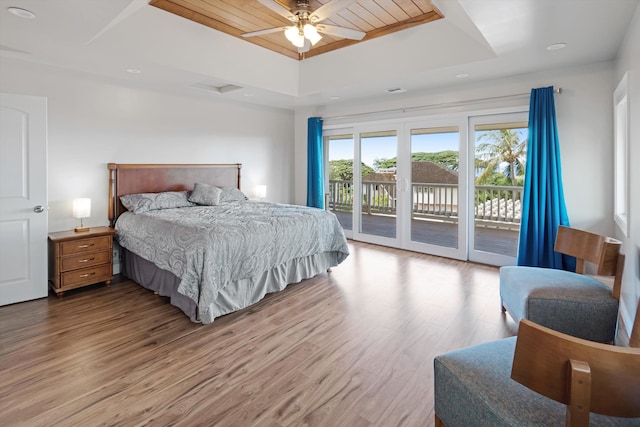 bedroom featuring wood ceiling, ceiling fan, access to exterior, a tray ceiling, and light wood-type flooring