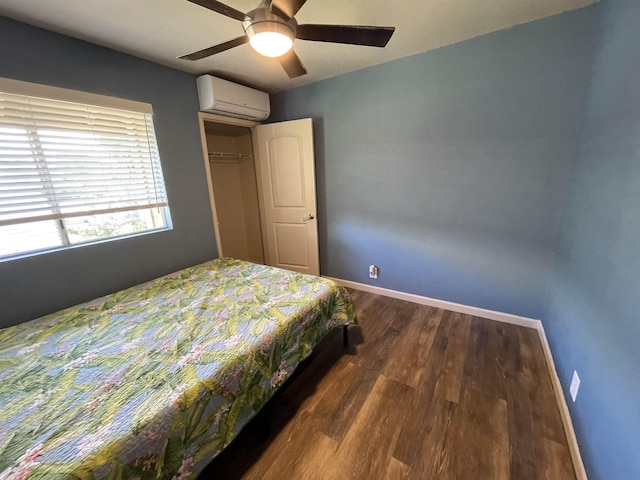 bedroom with dark wood-type flooring, a wall unit AC, a closet, and ceiling fan