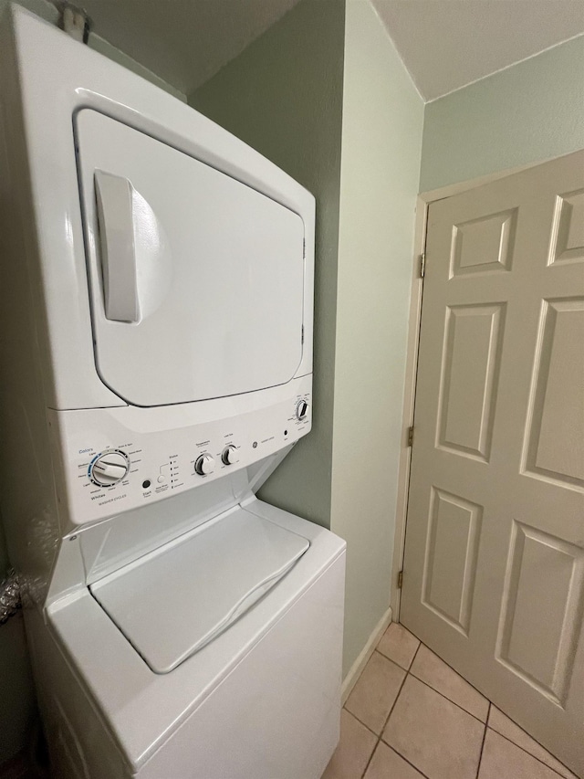 washroom featuring stacked washer and clothes dryer and light tile patterned floors