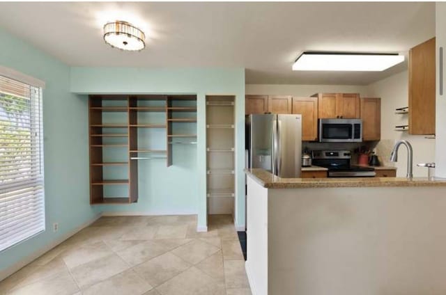 kitchen with sink, light tile patterned floors, and stainless steel appliances