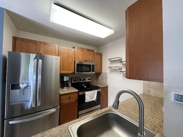 kitchen featuring tasteful backsplash, appliances with stainless steel finishes, and sink