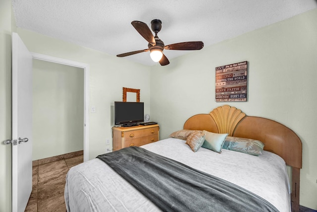 bedroom featuring a textured ceiling, ceiling fan, and baseboards