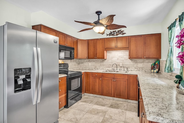 kitchen featuring brown cabinetry, black appliances, backsplash, and a sink