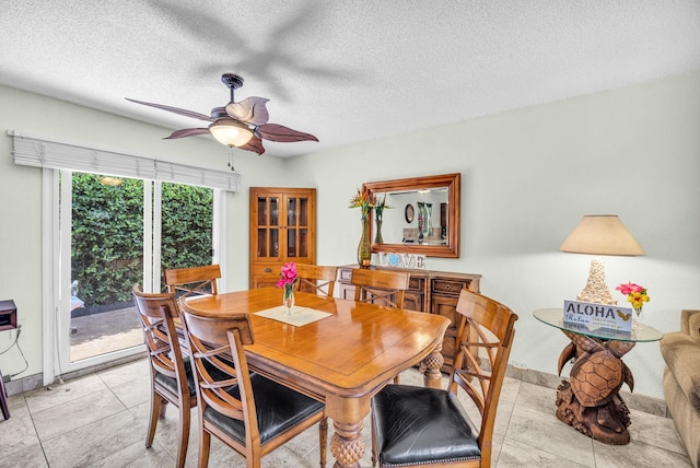 dining area with light tile patterned floors, a ceiling fan, and a textured ceiling