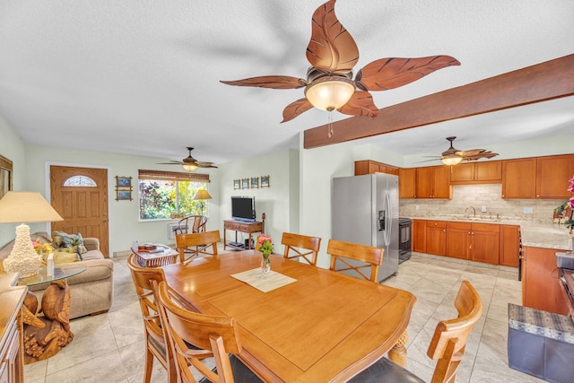 dining area featuring light tile patterned floors, a ceiling fan, and a textured ceiling