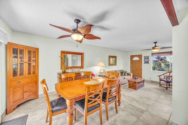 dining area featuring a textured ceiling and a ceiling fan