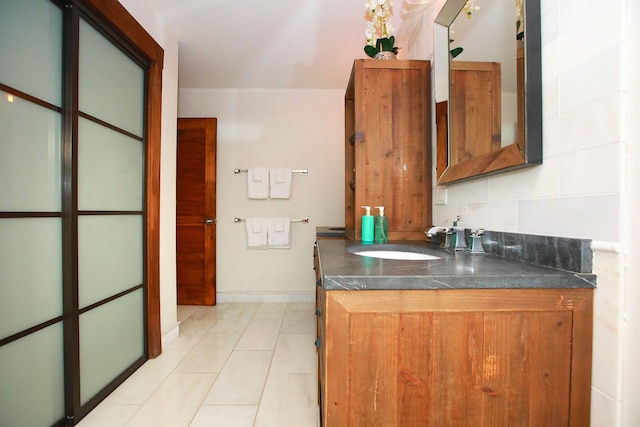 interior space featuring tasteful backsplash, tile floors, and vanity