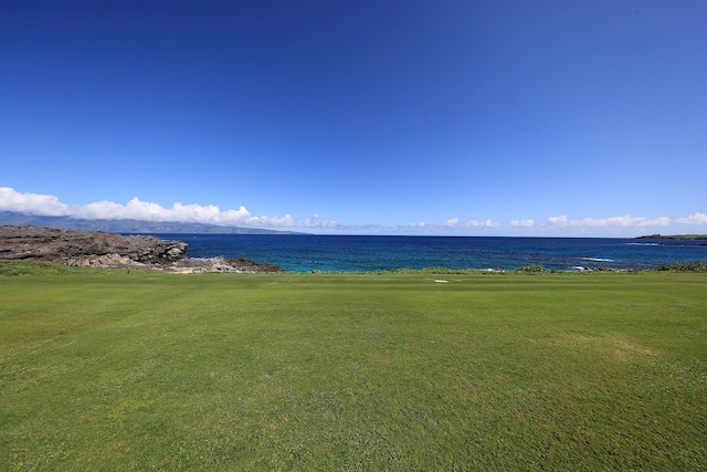 view of property's community with a water view and a lawn