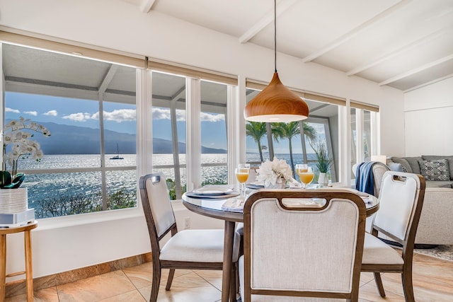 sunroom featuring a water view and vaulted ceiling with beams