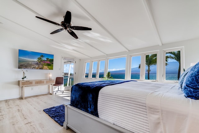 bedroom featuring lofted ceiling with beams, light hardwood / wood-style floors, ceiling fan, and a water view