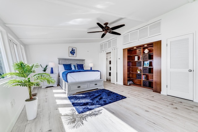 bedroom with ceiling fan, beam ceiling, and light hardwood / wood-style flooring