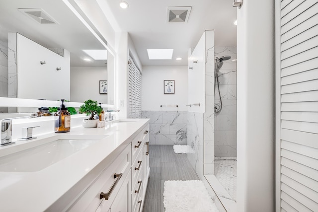 bathroom featuring vanity, tiled shower, and tile walls