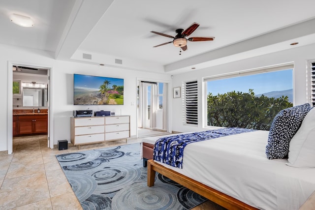 tiled bedroom featuring ceiling fan and ensuite bath