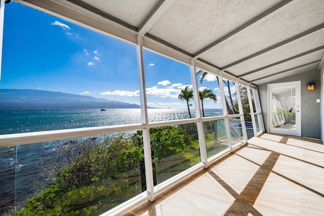 unfurnished sunroom with a water and mountain view and a beach view