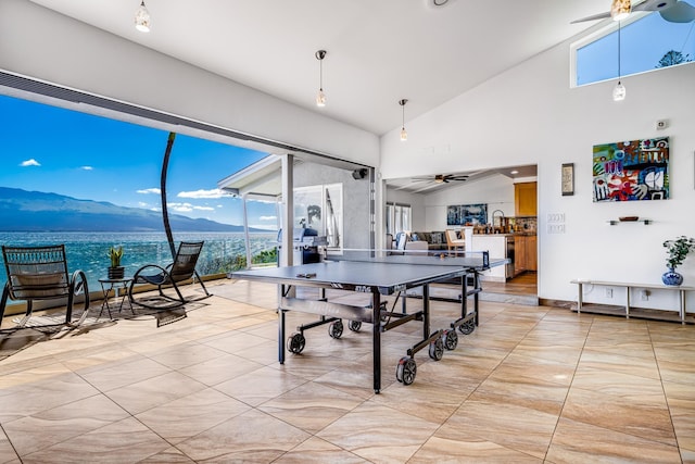 game room featuring ceiling fan, vaulted ceiling, and a water and mountain view