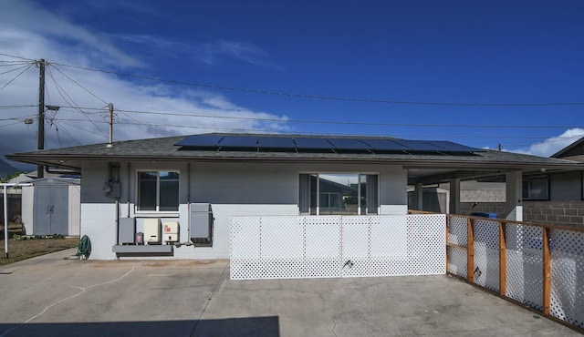 view of front of home with a storage shed and solar panels