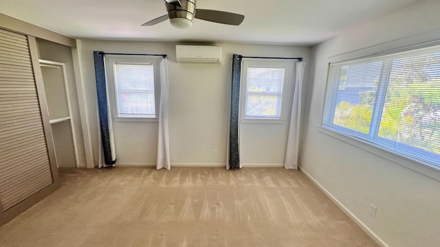 unfurnished bedroom with an AC wall unit, light colored carpet, and ceiling fan