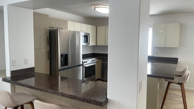 kitchen featuring a peninsula, a breakfast bar, and stainless steel appliances