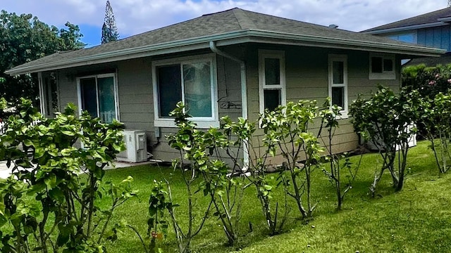 view of property exterior with a yard and ac unit