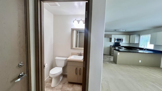 bathroom featuring tile patterned flooring, vanity, and toilet