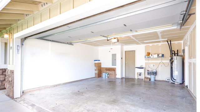 garage featuring a garage door opener, electric panel, a sink, and electric water heater
