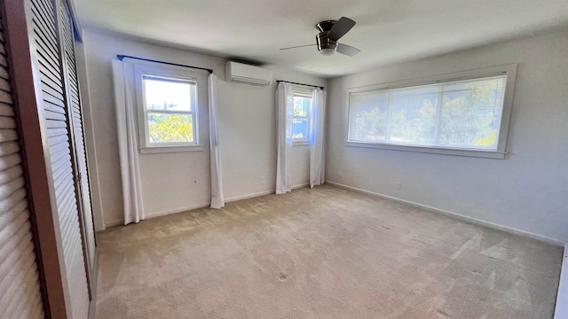 unfurnished bedroom featuring multiple windows, light colored carpet, an AC wall unit, and ceiling fan