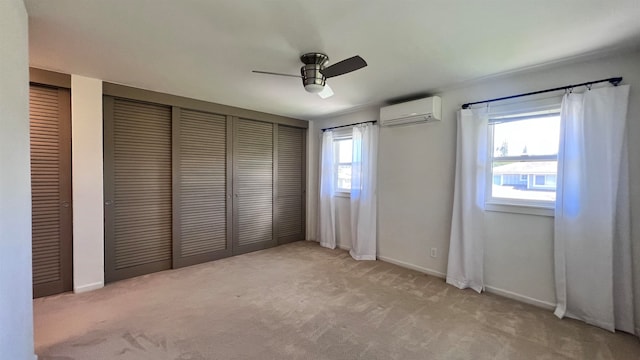 unfurnished bedroom with a wall mounted AC, light carpet, ceiling fan, and two closets