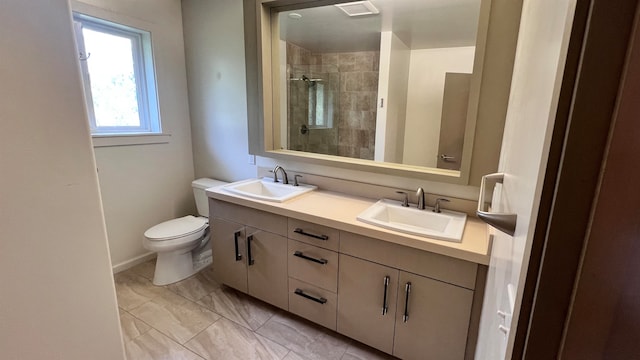 full bathroom with a tile shower, double vanity, a sink, and toilet