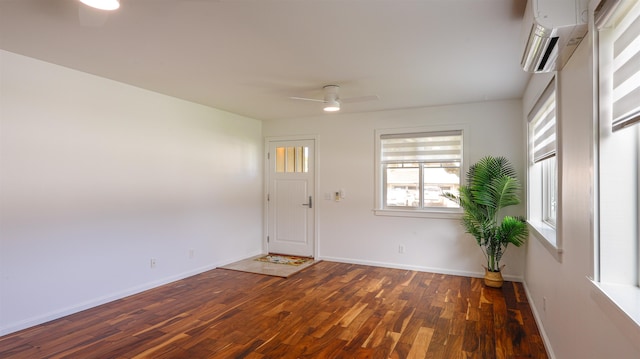 entrance foyer featuring baseboards, a wall mounted AC, ceiling fan, and wood finished floors