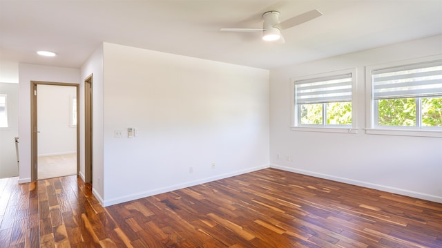 spare room with ceiling fan, baseboards, and dark wood-style flooring