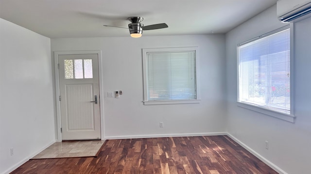 entryway featuring dark wood-type flooring, ceiling fan, plenty of natural light, and an AC wall unit