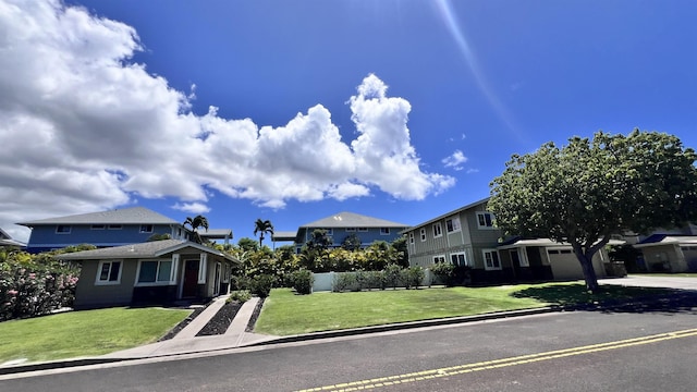 view of front of property with a garage, a front yard, driveway, and a residential view