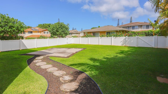 view of yard featuring a patio area, a fenced backyard, and a residential view