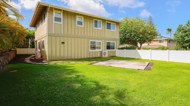 back of property with board and batten siding, central AC, a yard, a fenced backyard, and a patio