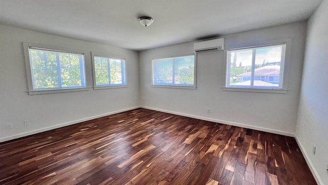 spare room with an AC wall unit and dark hardwood / wood-style floors