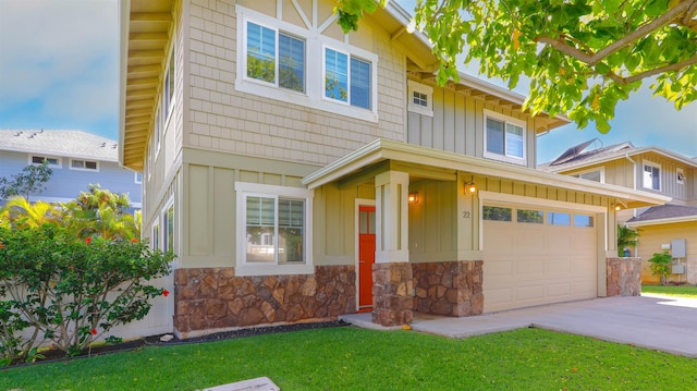 view of front of home featuring stone siding, a garage, board and batten siding, concrete driveway, and a front lawn