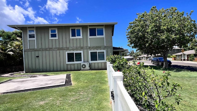 rear view of house with ac unit, a patio, a lawn, board and batten siding, and fence