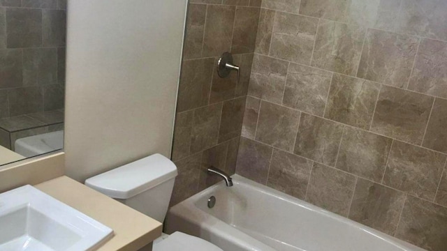 full bathroom with vanity, tiled shower / bath combo, and toilet