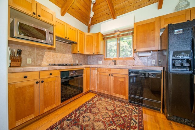 kitchen featuring light hardwood / wood-style floors, black appliances, lofted ceiling with beams, sink, and wooden ceiling