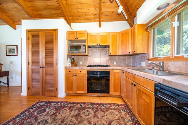 kitchen featuring black appliances, wood ceiling, vaulted ceiling with beams, sink, and light hardwood / wood-style flooring