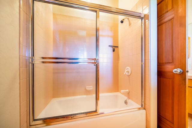 bathroom featuring bath / shower combo with glass door