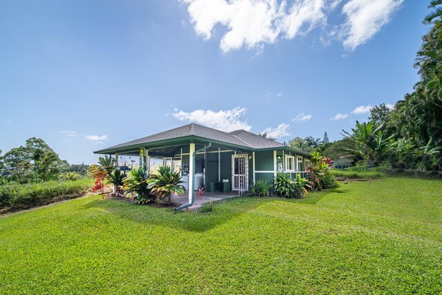 rear view of house featuring a lawn