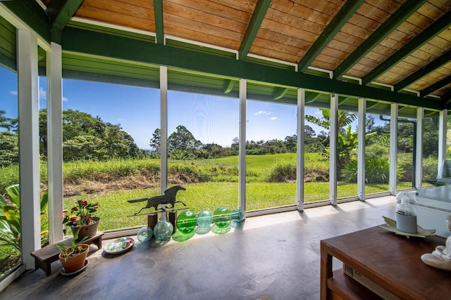 unfurnished sunroom featuring wood ceiling and vaulted ceiling with beams