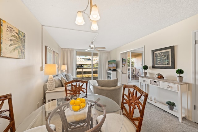 carpeted dining area featuring ceiling fan with notable chandelier