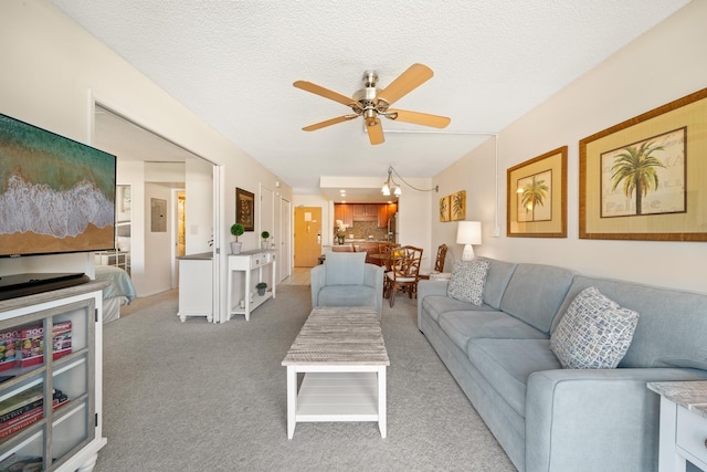 living room featuring ceiling fan, carpet, and a textured ceiling