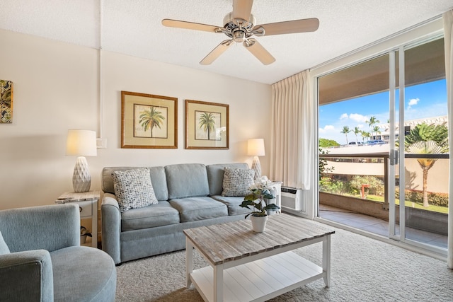 living room with carpet, a ceiling fan, and a textured ceiling